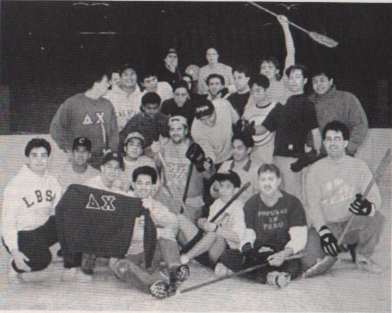 A vintage black-and-white photo of a large group of young men posing indoors.